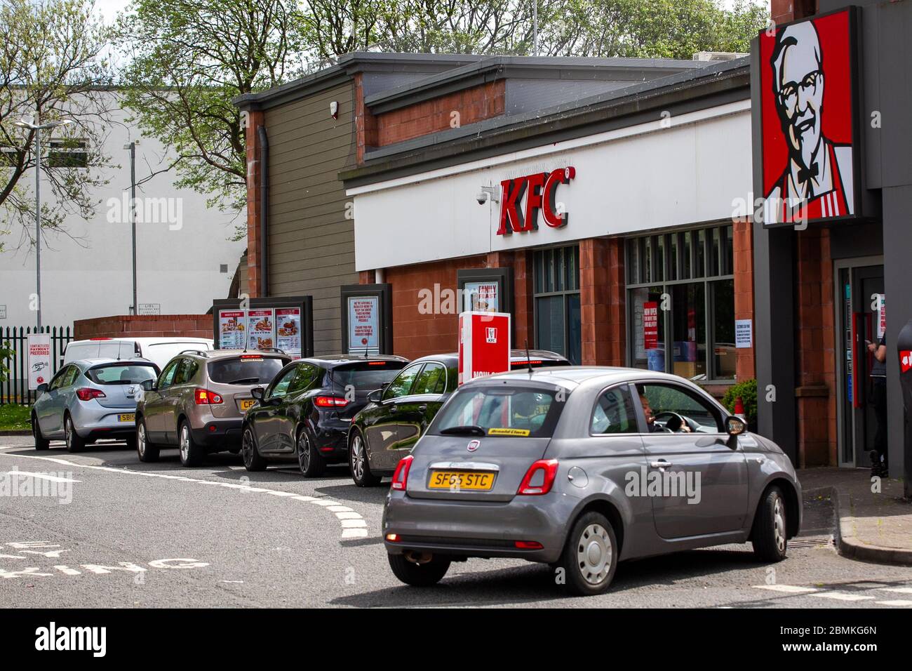 Eine Schlange von Autos, die während der Sperrung der Corona-Virus-Pandemie in ein KFC Drive Thru-Restaurant in Glasgow, Schottland, Großbritannien, fahren. Stockfoto