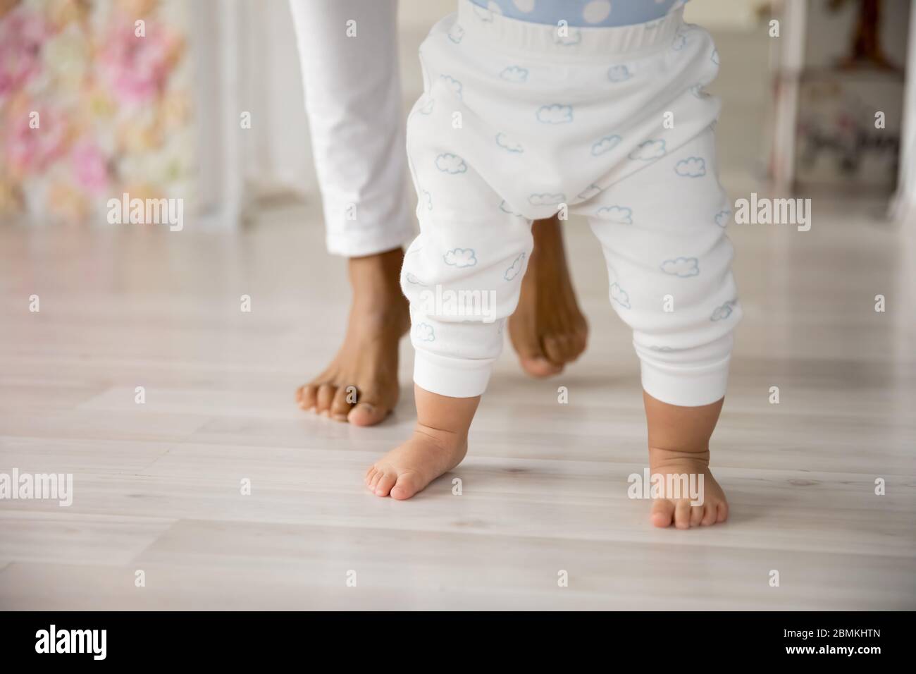 Nahaufnahme von kleinen Baby machen erste Schritte mit Mama Stockfoto