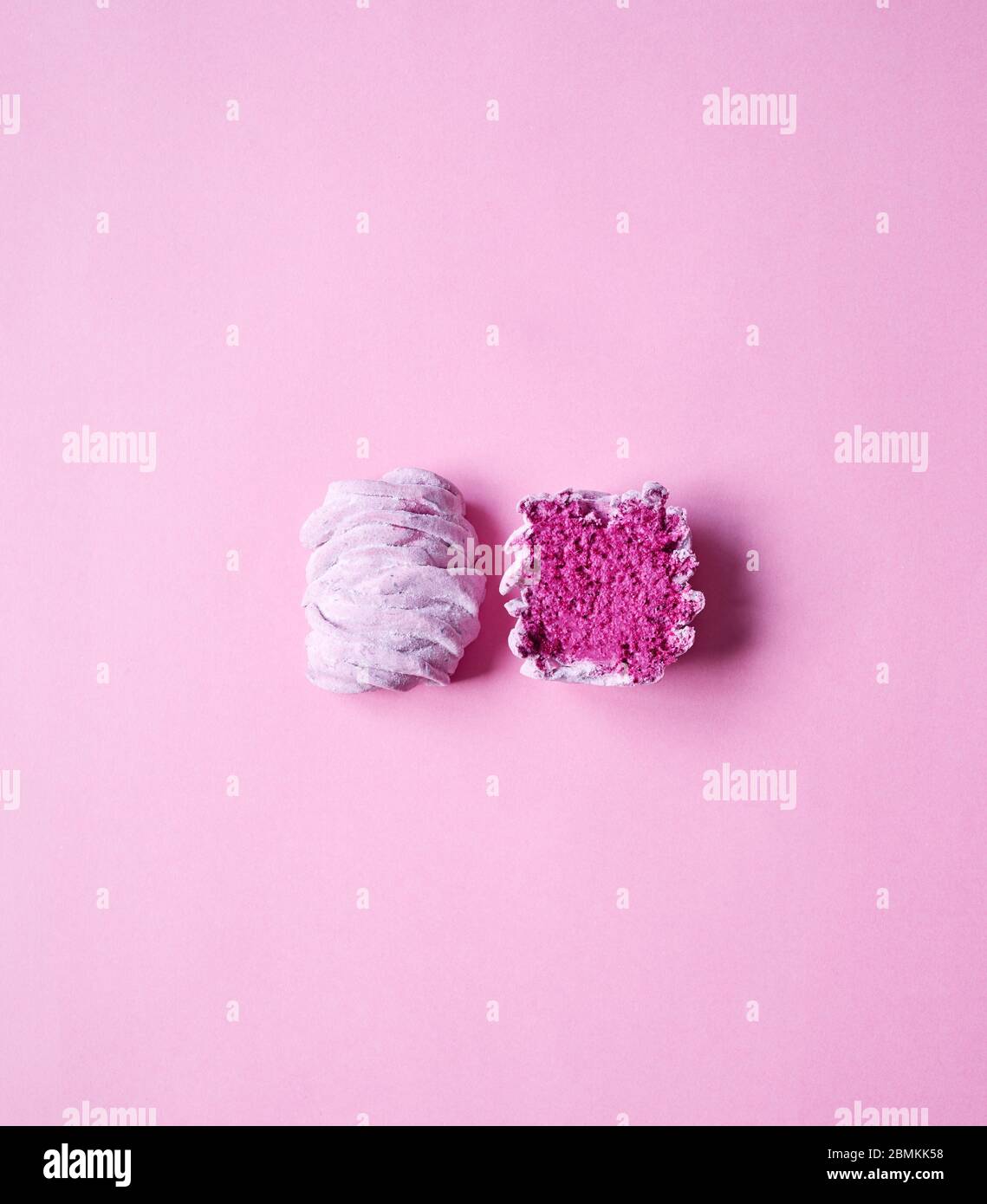 Minimalismus Kunst mit Schnitt Violett süß hausgemachte Zephyr oder Marshmallow aus schwarzer Johannisbeere auf rosa hellen Hintergrund Draufsicht Stockfoto