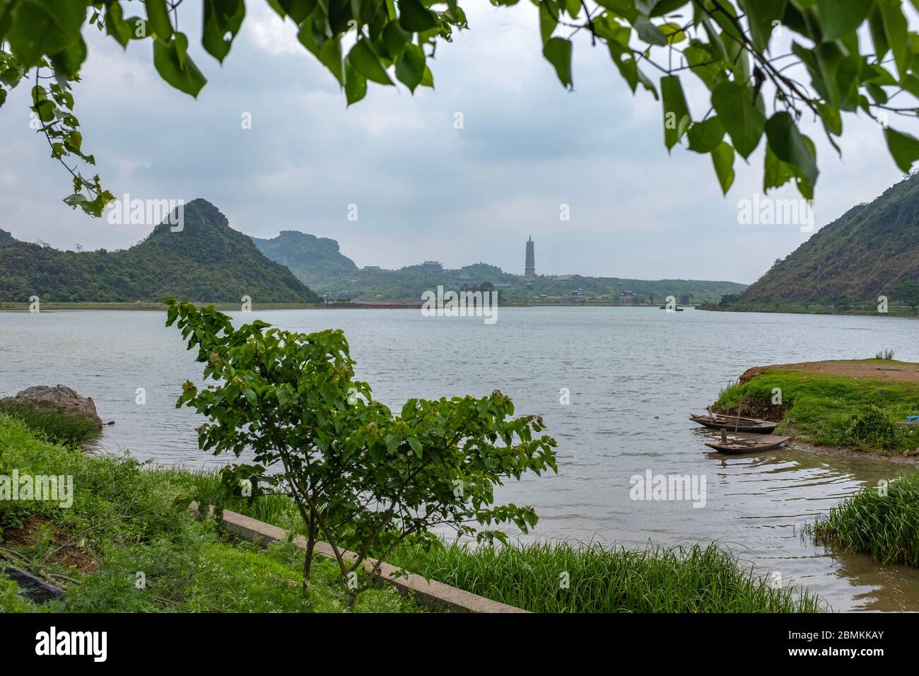Gerahmter Blick auf das Chua Bai Dinh buddhistische Kloster von einem See, aufgenommen an einem bewölkten Tag, Ninh Binh Provinz, vietnam Stockfoto
