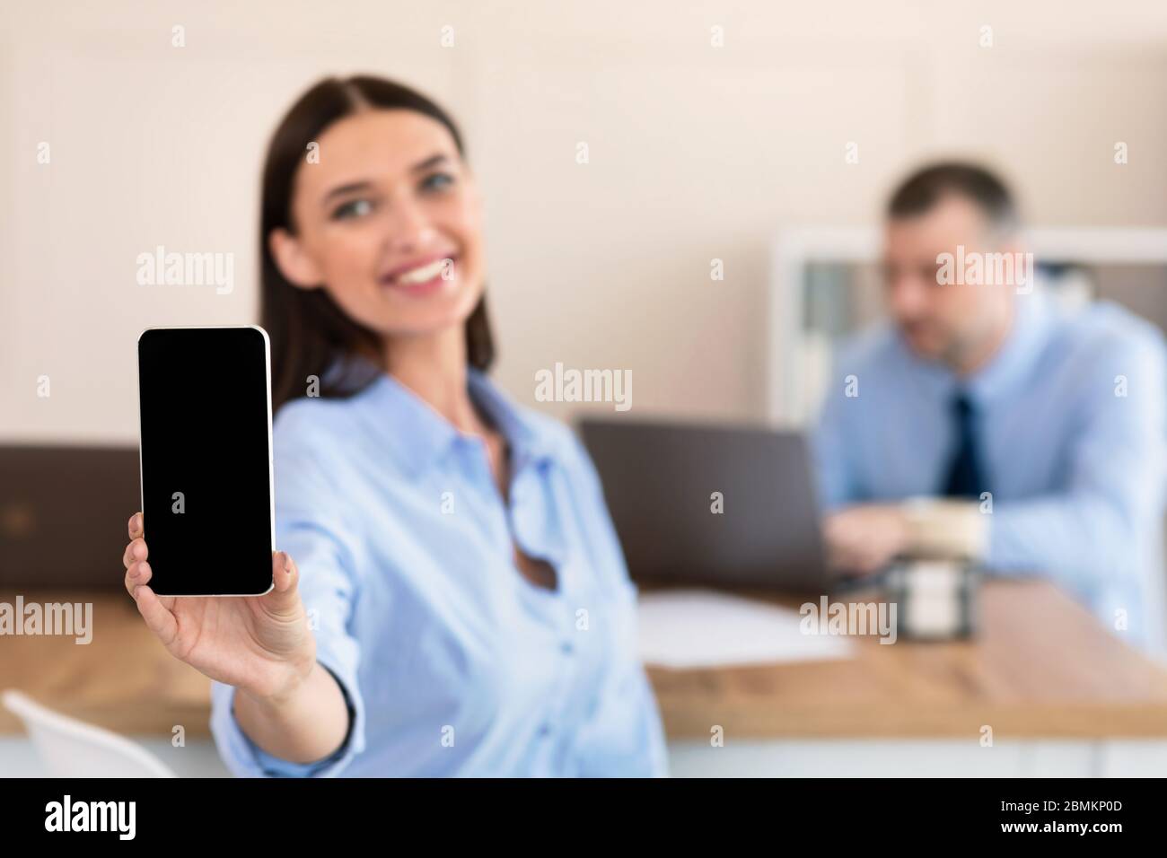 Geschäftsfrau Zeigt Smartphone Leeren Bildschirm Sitzt Mit Kollegen Im Büro Stockfoto