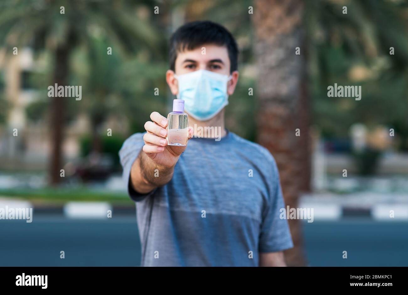 Mann hält Hand Desinfektionsmittel als covid 19 Vorsichtsmaßnahme und Desinfektion im Freien Stockfoto