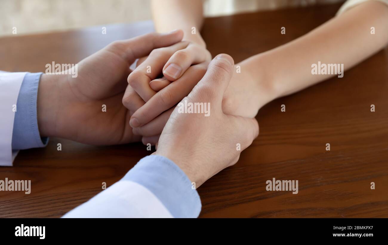 Nahaufnahme von männlichen Arzt Komfort weiblichen Patienten Stockfoto