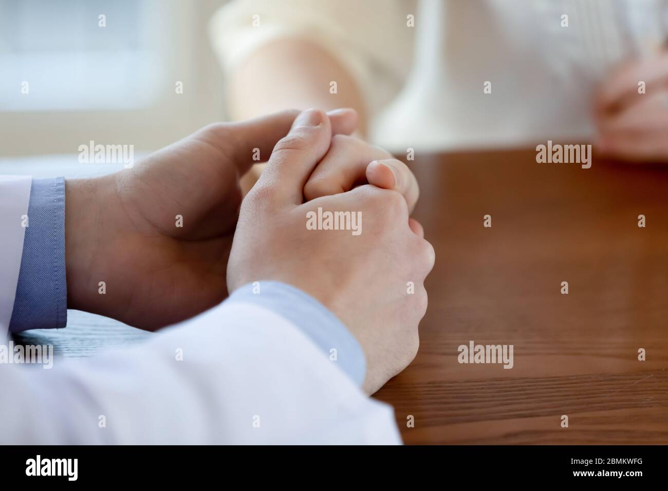 Nahaufnahme der Pflege männlichen Arzt Komfort weiblichen Patienten Stockfoto
