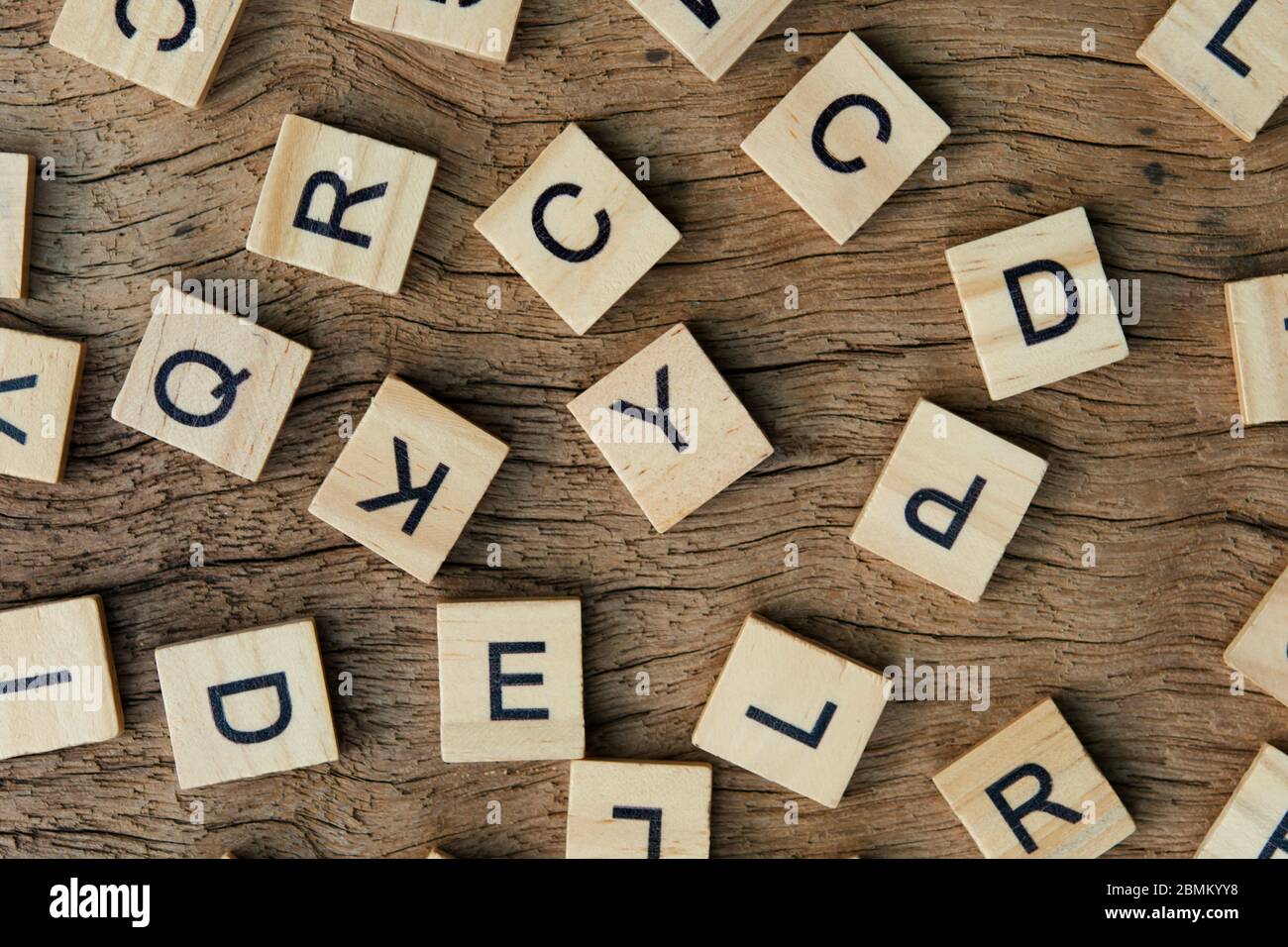 Hintergrund von Holzdruckblöcken auf Holzhintergrund, zufälligen Buchstaben des Alphabets und von schwarzen Tinten gefärbten Interpunktionszeichen Stockfoto