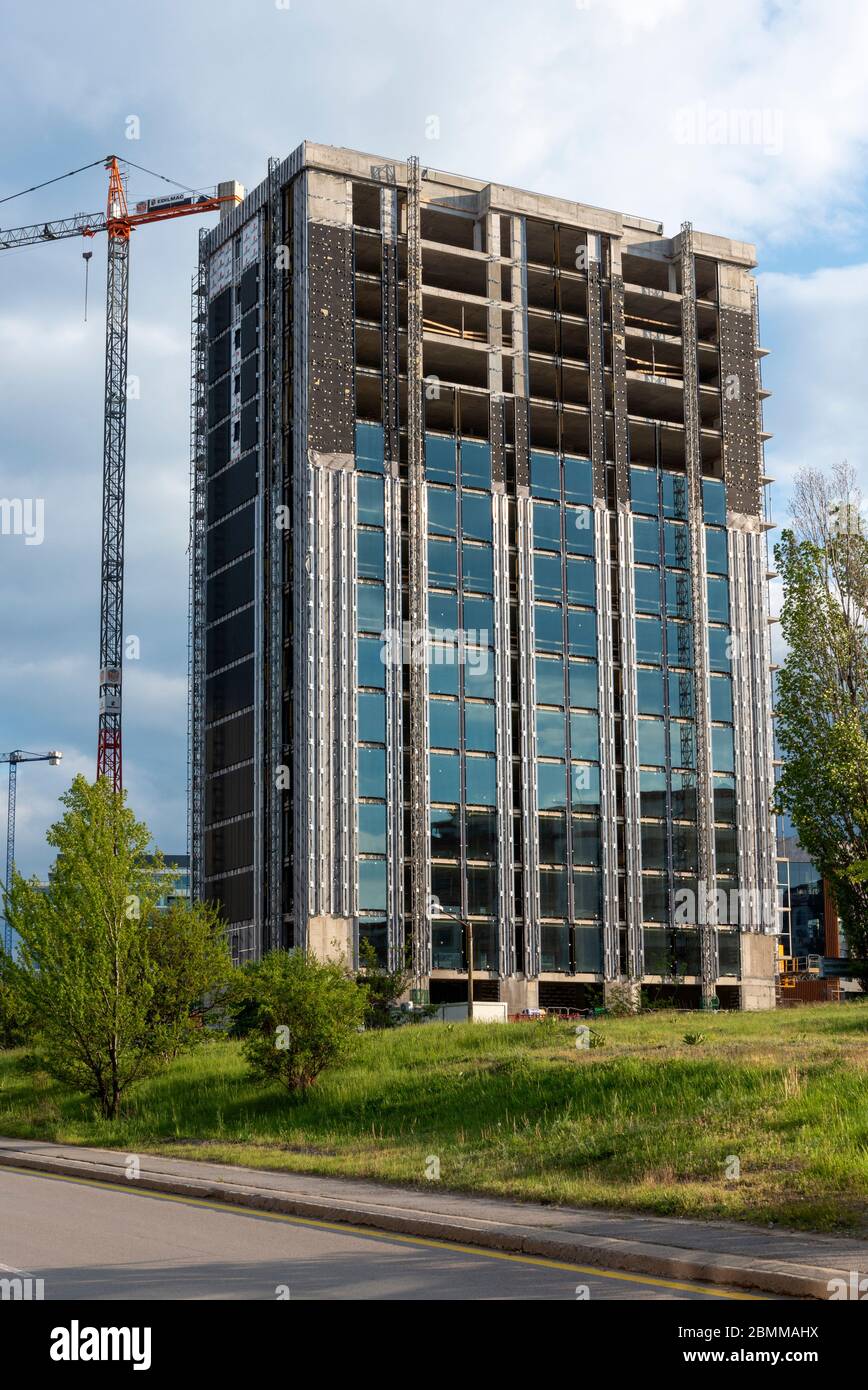 Die Arbeiten auf der Baustelle für Bürogebäude sind teilweise mit Glas und Aluminium bedeckt Stockfoto
