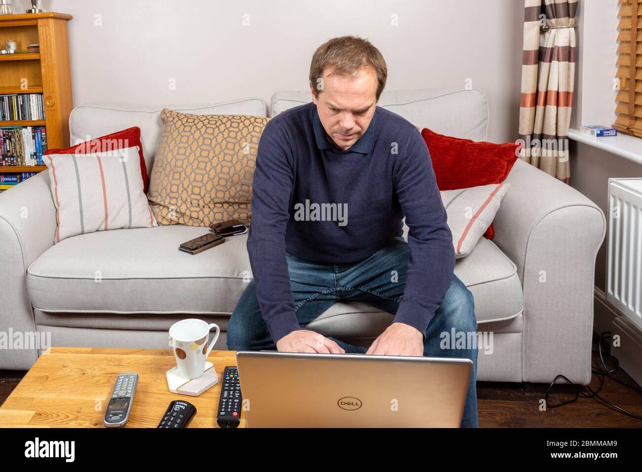 Mann, der von zu Hause aus von seinem Couchtisch arbeitet Stockfoto