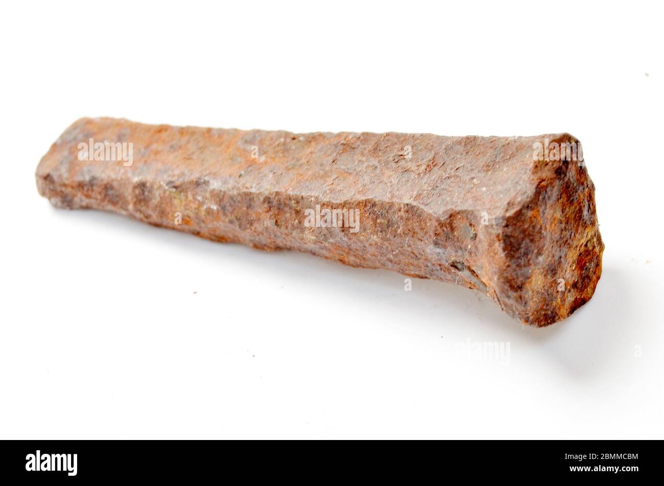 Alte rostige Metallspitze oder großer Nagel, die in einem alten Steinbruch gefunden wurden Stockfoto