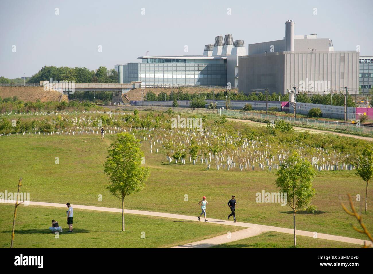 Trumpington Landschaftspark Jogger Astra Zeneca und Labor für Molekularbiologie im Hintergrund Stockfoto