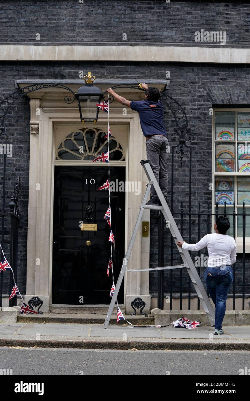 Downing Street Mitarbeiter entfernen Union Flagge Bunting von der Front der Nr. 10 Downing Street nach VE Tag, vor Premierminister Boris Johnson Rede an die Nation später am Abend. Stockfoto