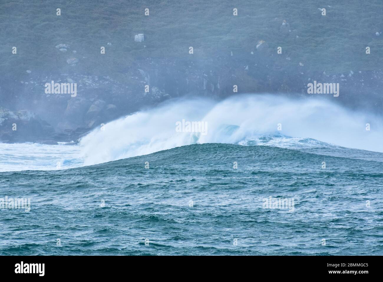 Große Wellen treffen auf die Felsen in rauer See. An einem bewölkten Tag. Galicien Spanien. Stockfoto