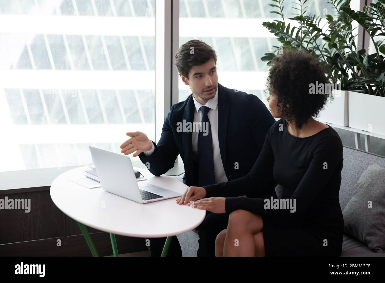Kollegen aus verschiedenen Rassen diskutieren während eines Meetings im Büro über neue Geschäftsanwendungen Stockfoto