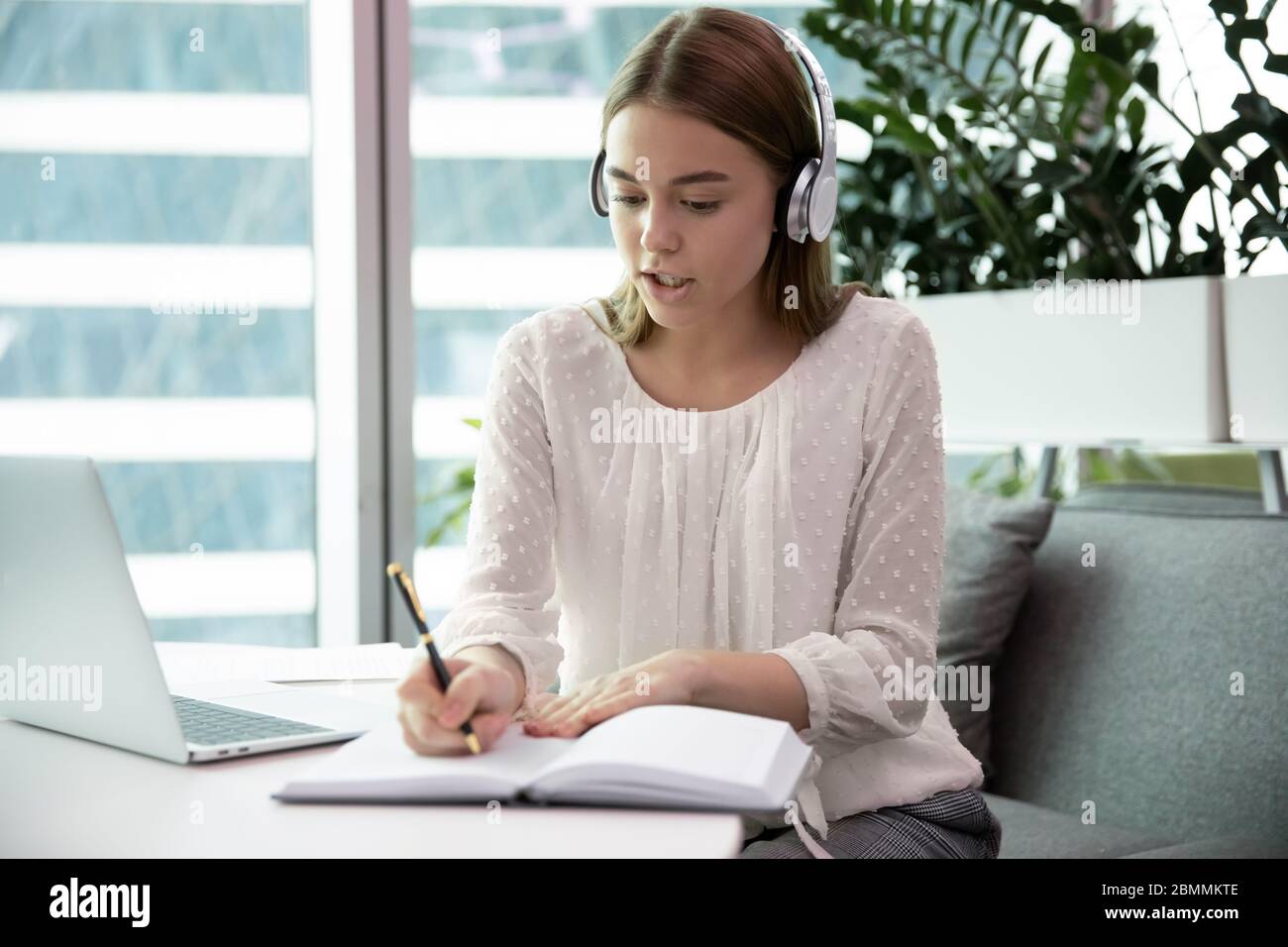 Geschäftsfrau trägt Kopfhörer in Geschäftskonferenz mit Firmenkunden beteiligt Stockfoto