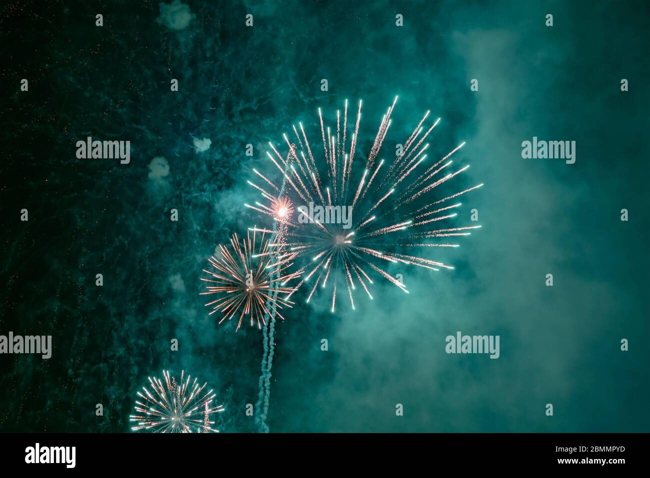 Grünes Feuerwerk mit Rauch über dem schwarzen Himmel. Geringe Tastenbelichtung. Stockfoto