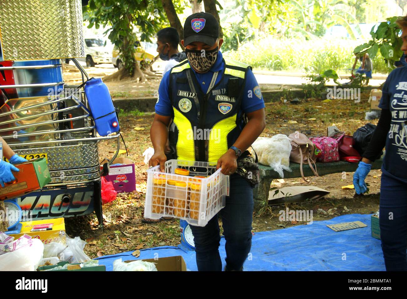 Antipolo City, Philippinen - 7. Mai 2020: Ein Polizist hilft bei einem mobilen Palengke oder Markt, der von der lokalen Regierung in einer Gemeinde d organisiert wird Stockfoto