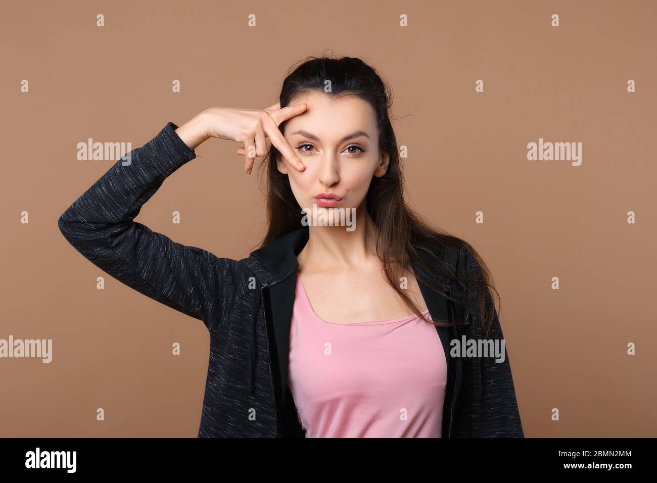 Verspielt Mädchen machen Entengesicht isoliert auf beigem Hintergrund Stockfoto