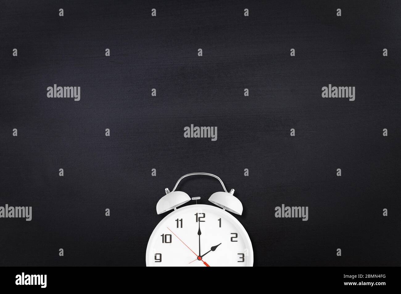 Weißer Wecker mit zwei Glocken und Klingelton auf schwarzer Tafel als  Hintergrund Stockfotografie - Alamy