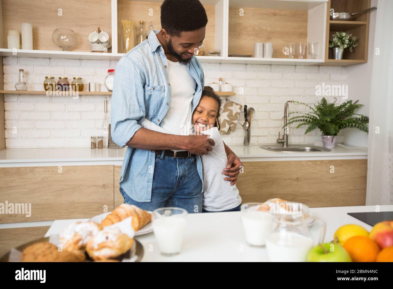 Dankbar kleines Mädchen umarmt ihren Papa mit Liebe in der Küche Stockfoto