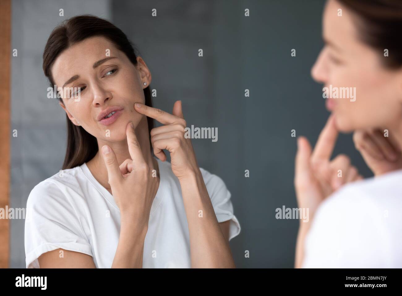 Frau berühren Haut Gesicht quetscht Pickel Haut Probleme Konzept Stockfoto