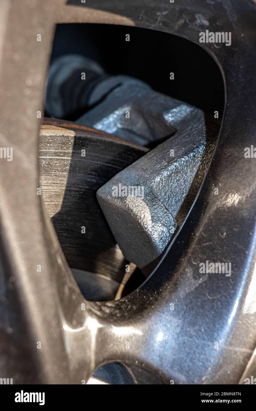 Der detaillierte Blick auf eine Scheibenbremse des modernen Autos. Bremsbeläge an Bremsscheibe, Nahaufnahme. Stockfoto