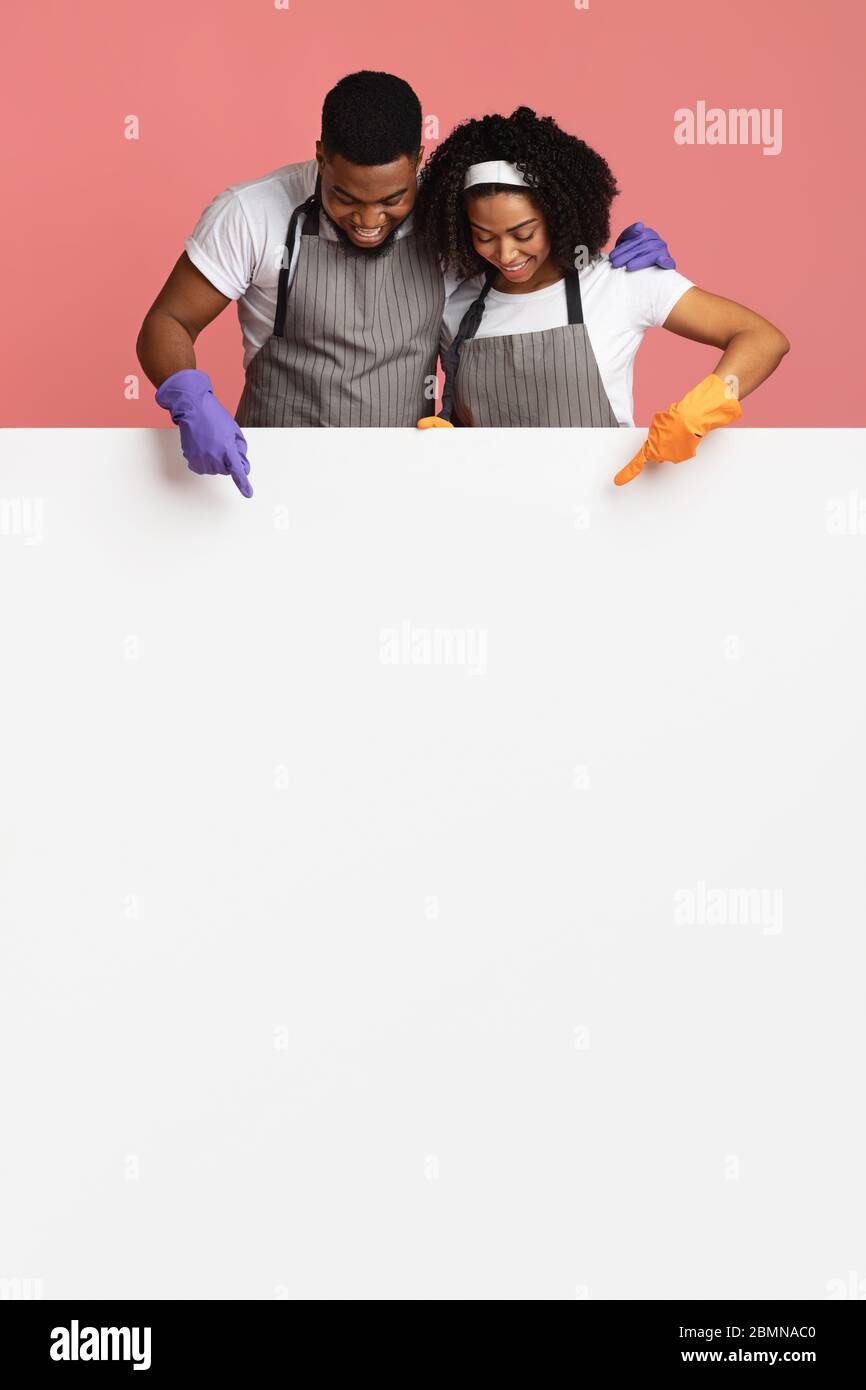 Reinigungsservice. Glückliches Afrikanisches Paar, Das Auf Weißes Reklamebrett Zeigt Stockfoto