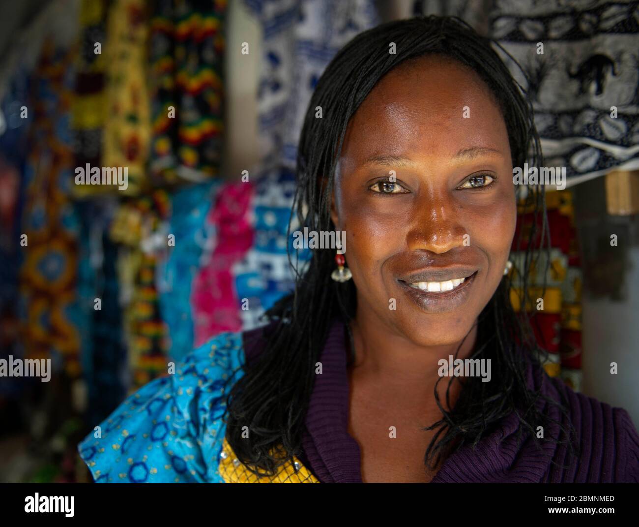 Senegalesische Frau posiert für ein Bild an ihrem Stoffstand in Dakar Senegal. Stockfoto