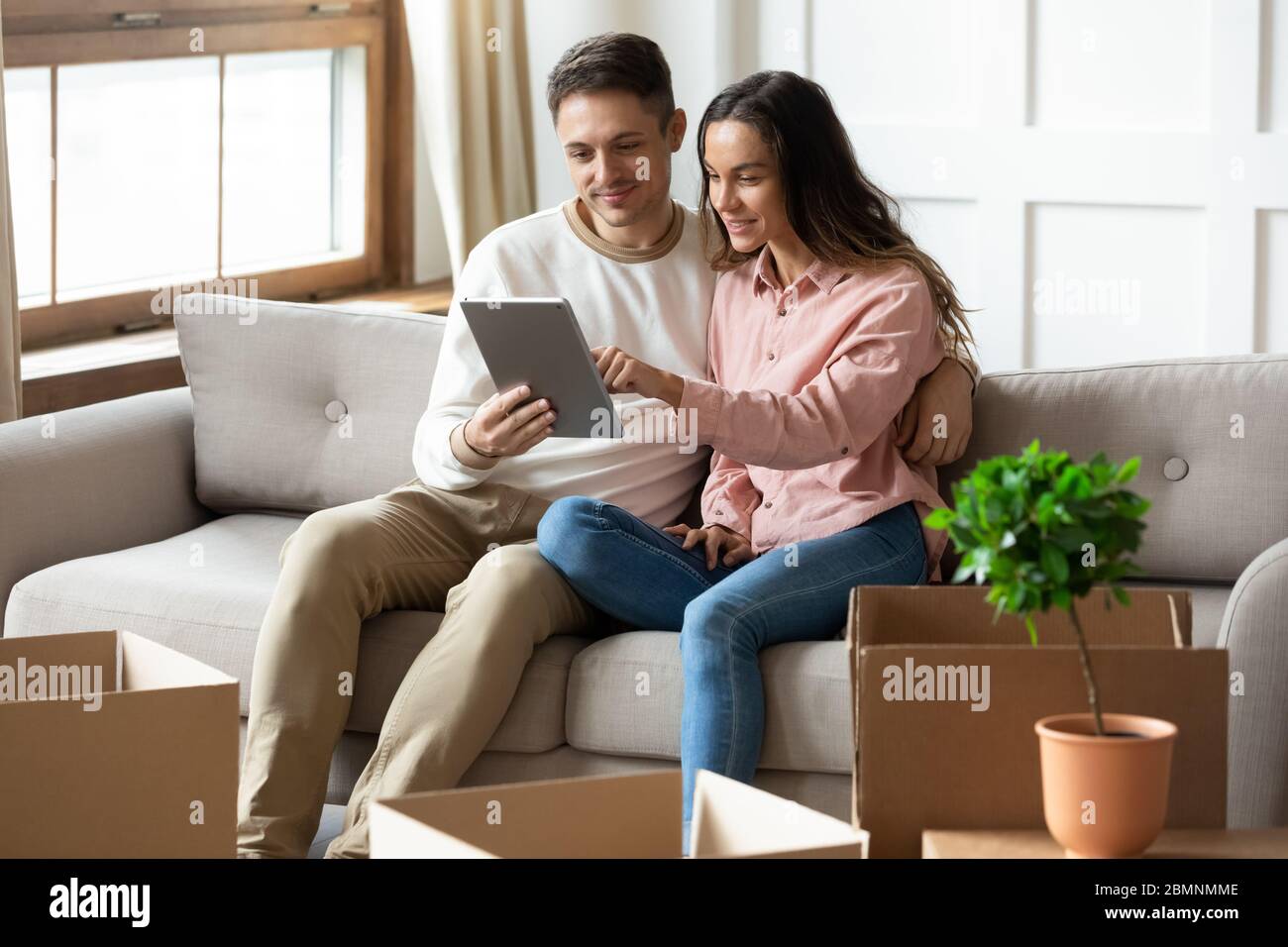 Glücklich junge Paar mit Computer-Tablet, die Wahl bewegen Service Stockfoto