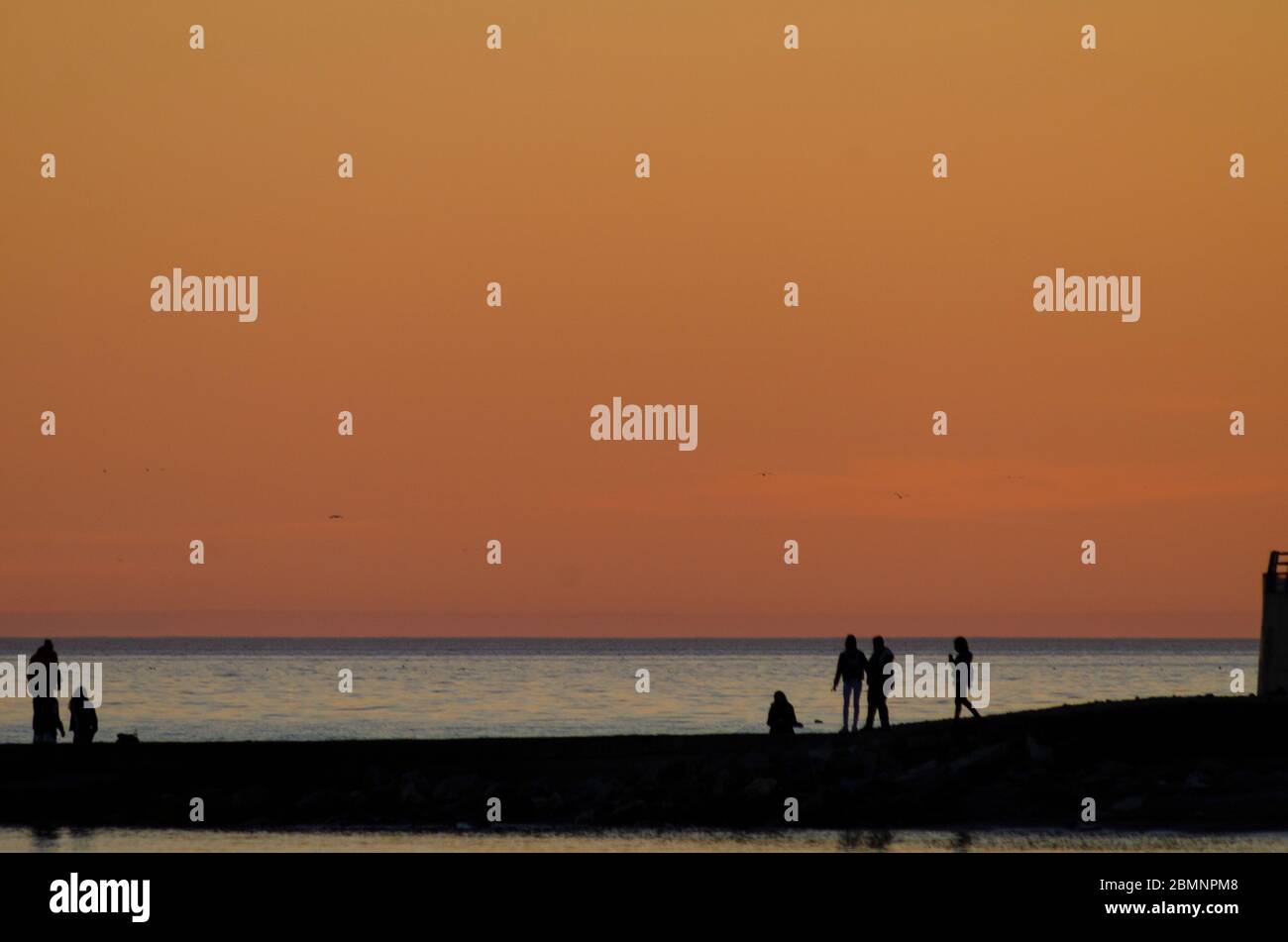 Menschen am Strand in der Abenddämmerung in Alexandroupoli Griechenland Stockfoto