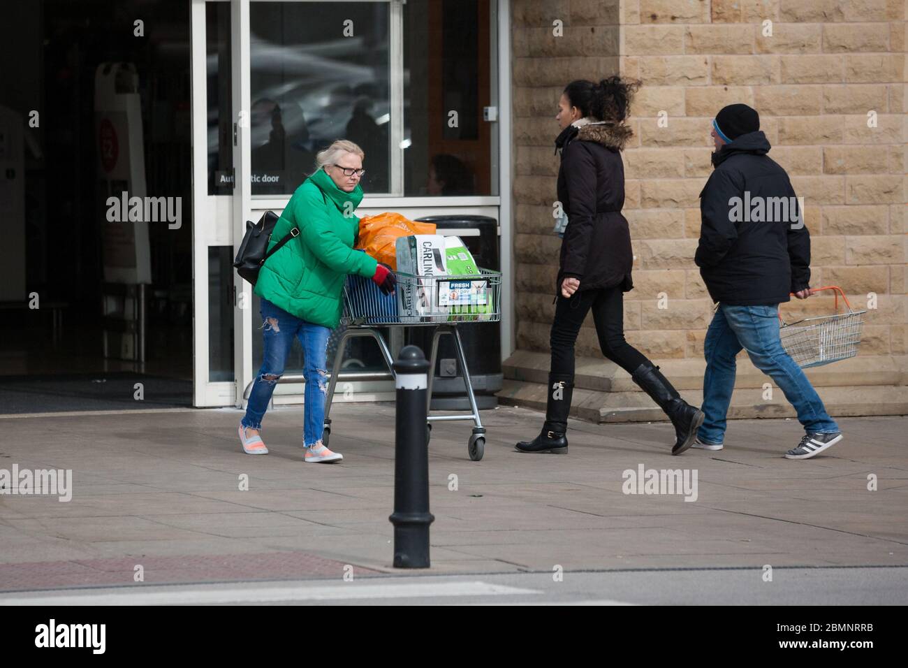 HUDDERSFIERLD, WEST YORKSHIRE, UK - MÄRZ 21: Ein Käufer verlässt einen Supermarkt mit einer Kiste Bier am Morgen nach dem Auftrag von Premierminister Boris Johnson Stockfoto