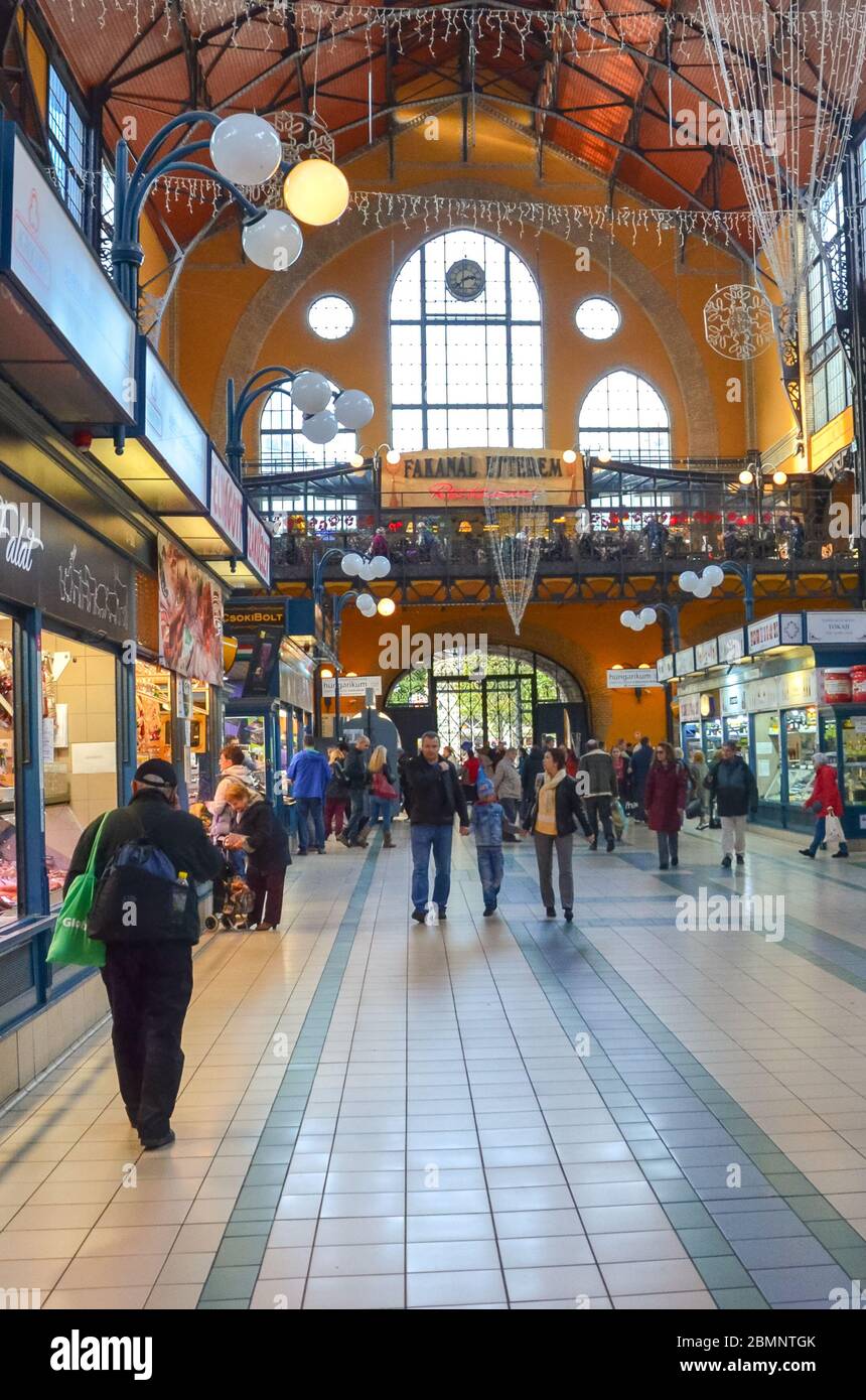 Budapest, Ungarn - 6. November 2019: Menschen einkaufen in der Großen Markthalle. Der größte Indoor-Markt der Stadt. Menschen einkaufen. Markt unter Dach. Treppen führen in den zweiten Stock. Vertikales Foto. Stockfoto