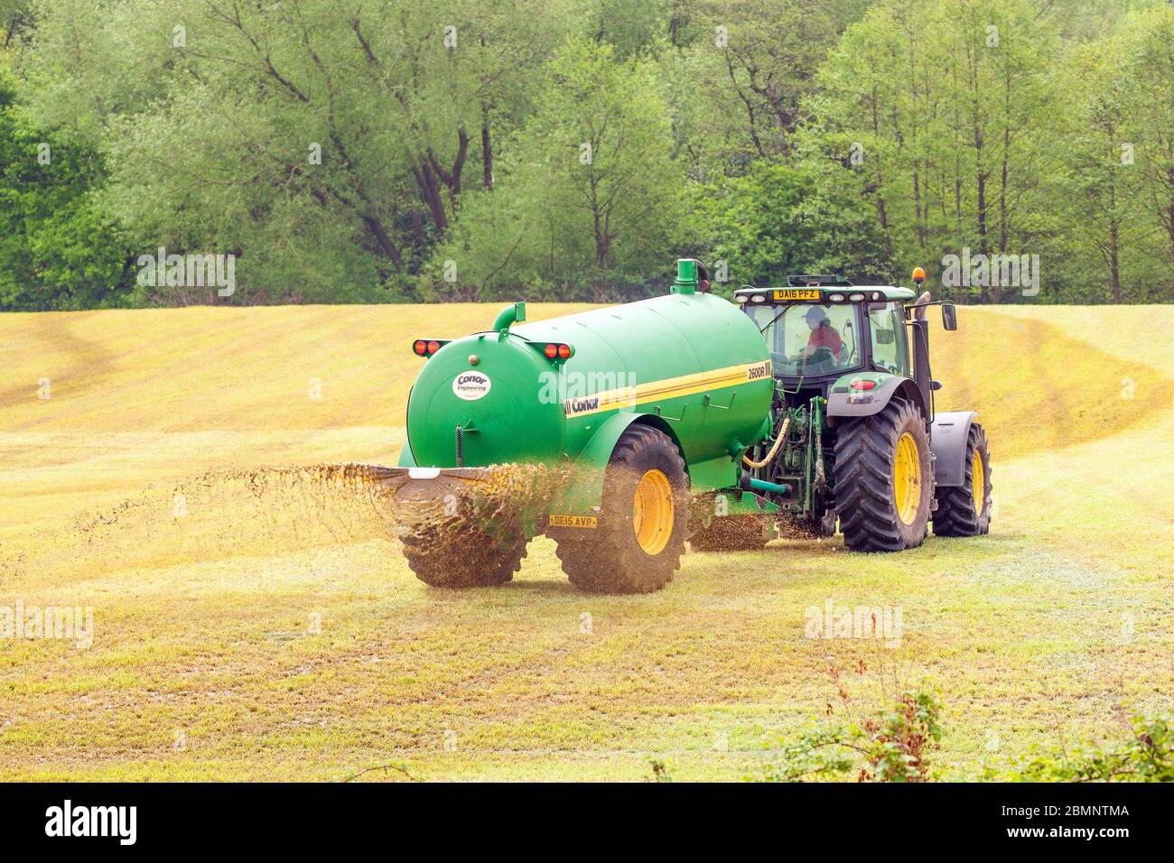 Landwirt verteilt Gülle auf einem landwirtschaftlichen Feld fahren einen John Deere 6930 Traktor in der Cheshire Landschaft England Stockfoto