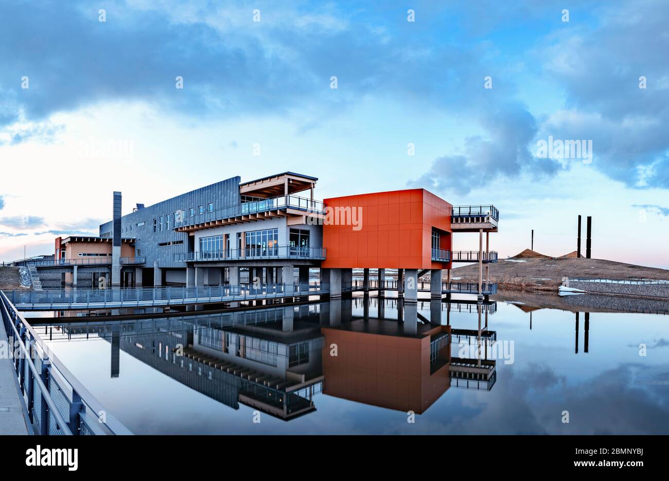 Eine Abendaufnahme des Ralph Klein Environmental Center, die sich im Wasser widerspiegelt Stockfoto