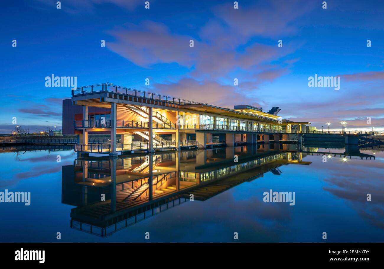 Das Ralph Klein Environmental Education Center während der blauen Stunde mit Reflexionen im See. Stockfoto