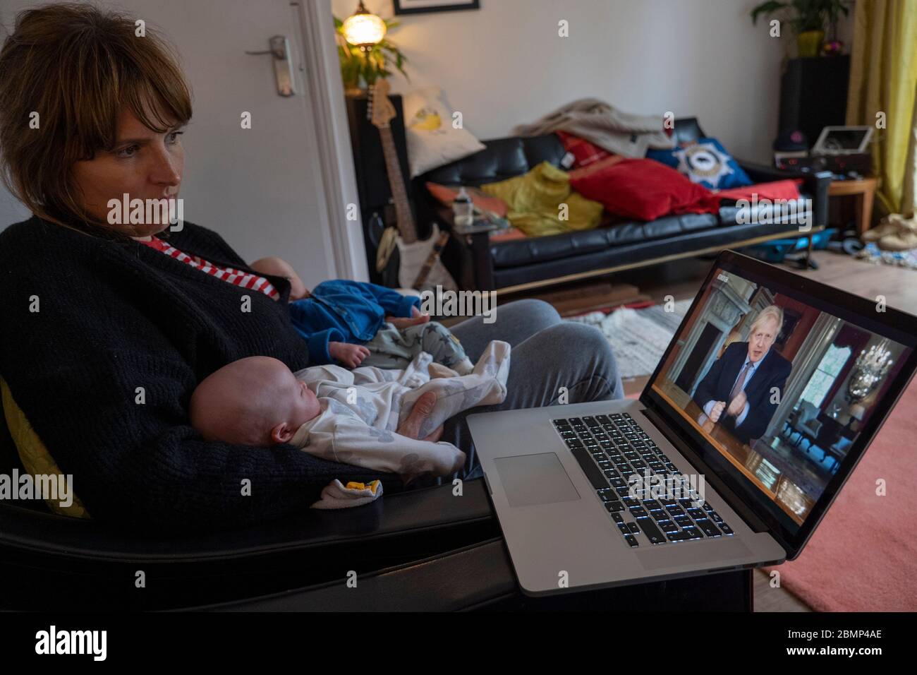 West Norwood, Großbritannien. Mai 2020. Eine Frau mit zwei neugeborenen Zwillingen sieht die BBC auf einem Laptop als britischer Premierminister spricht Boris Johnson mit neuen Phasen der Sperrung des Coronavirus die Nation an. Nach der Ankündigung sagte Boris Johnson, es sei "nicht die Zeit, die Sperre zu beenden" (Foto von Sam Mellish / Alamy Live News) Stockfoto