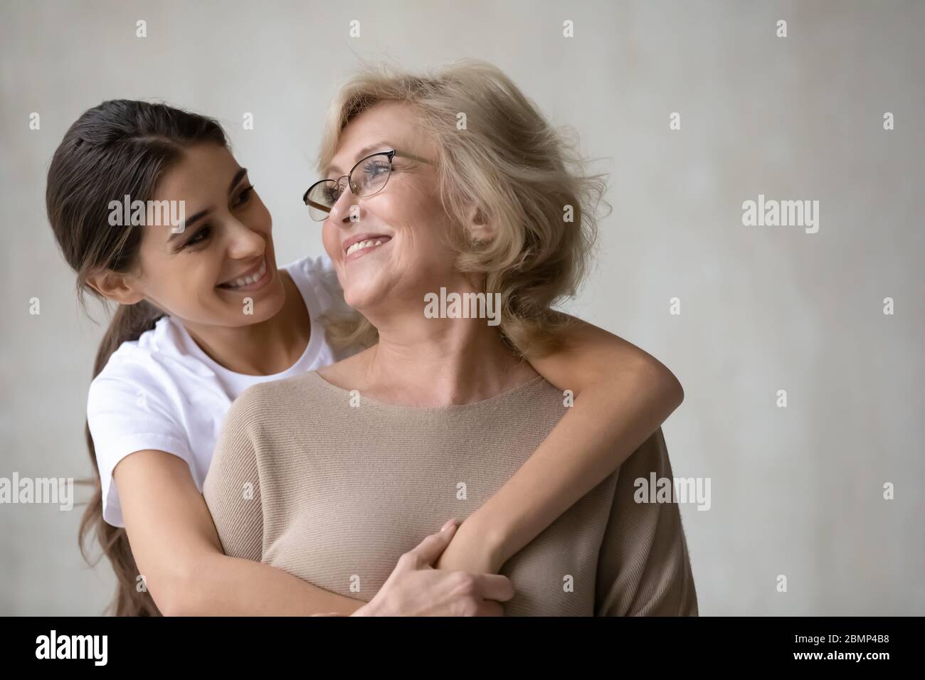 Erwachsene Tochter Umarmungen von hinten glücklich reif Mutter. Stockfoto