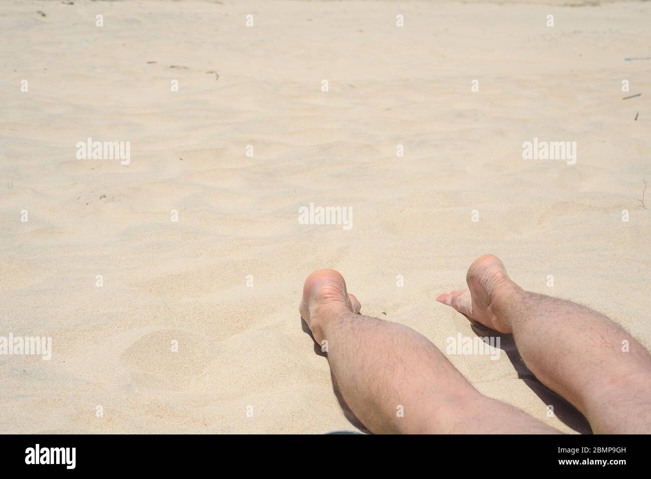 Mann, Ruhe, Strand, Beine des Mannes liegen am Strand Stockfoto