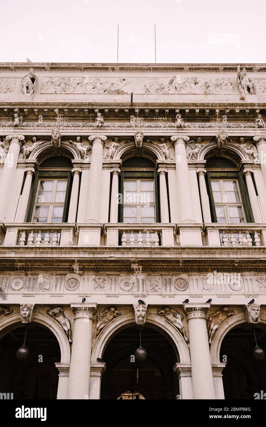 Verschnörkelte Fenster und Säulen im venezianischen Stil auf einem Fragment des luxuriösen Gebäudes in Venedig. Traditioneller antiker gotischer Stil. Drei Stockfoto