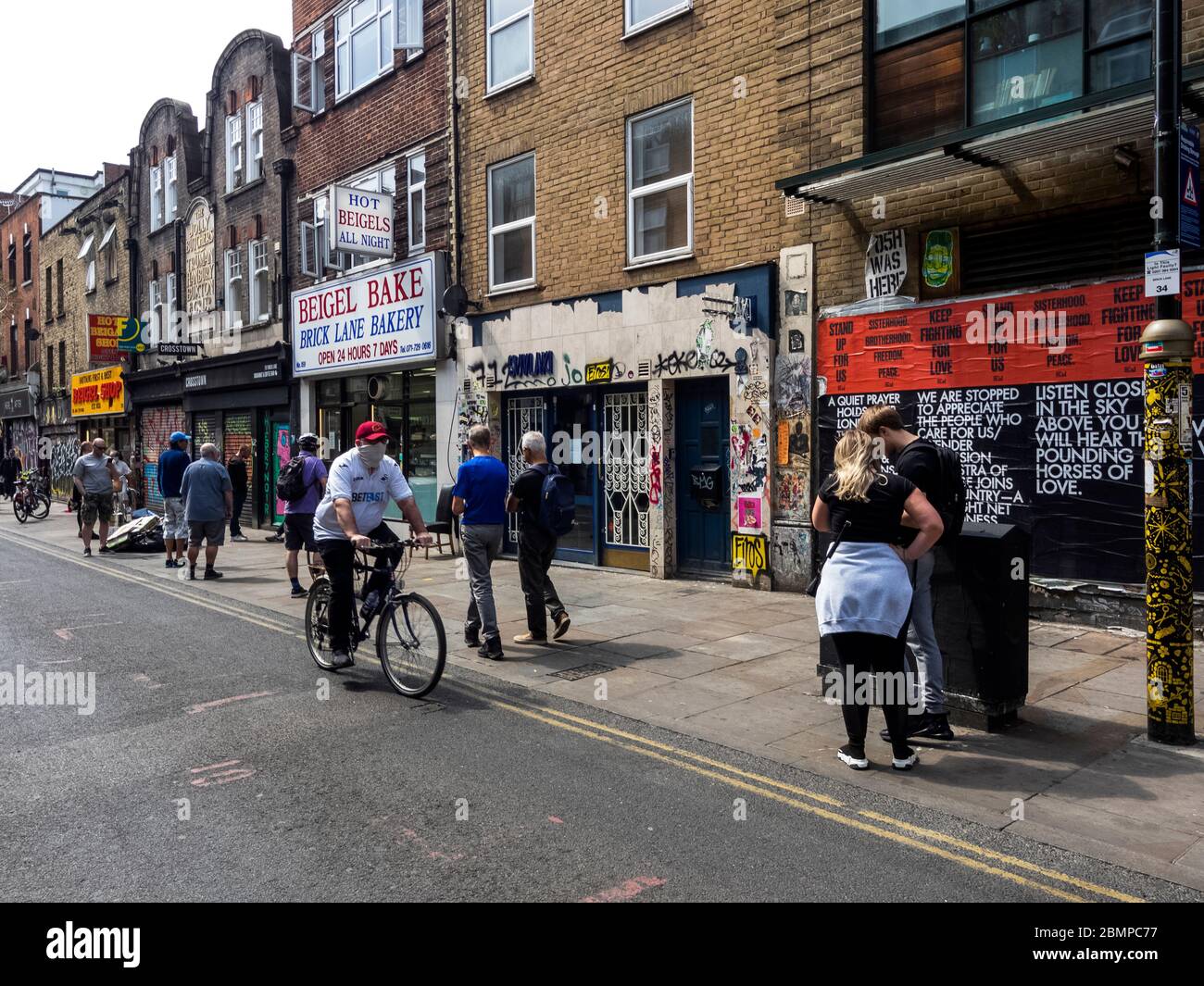 London. GROSSBRITANNIEN. Mai Sonntag, der 10. Mai 2020 um 12.00 Uhr. Blick auf die Leute, die sich während der Lockdown am Beigel Bake in der Brick Lane anstellen. Stockfoto