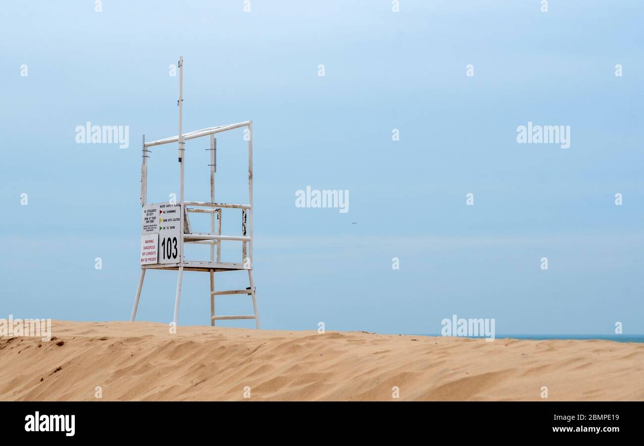 Ein trostloser Rettungsschwimmer-Stand blickt über einen leeren Strand, während Michigan USA während der COVID-19-Pandemie zusperrt und Hacke bleibt Stockfoto