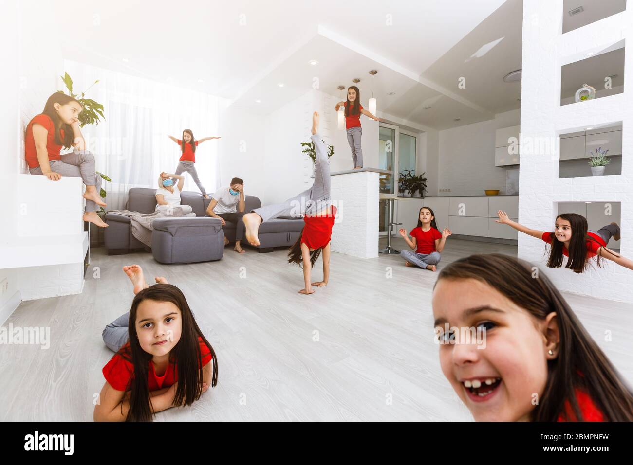 Erschöpft junge Eltern sitzen auf Couch in der Küche fühlen sich unwohl müde von schlecht erzogene laute kleine Kinder laufen spielen, krank genervte Mutter oder Kindermädchen Stockfoto