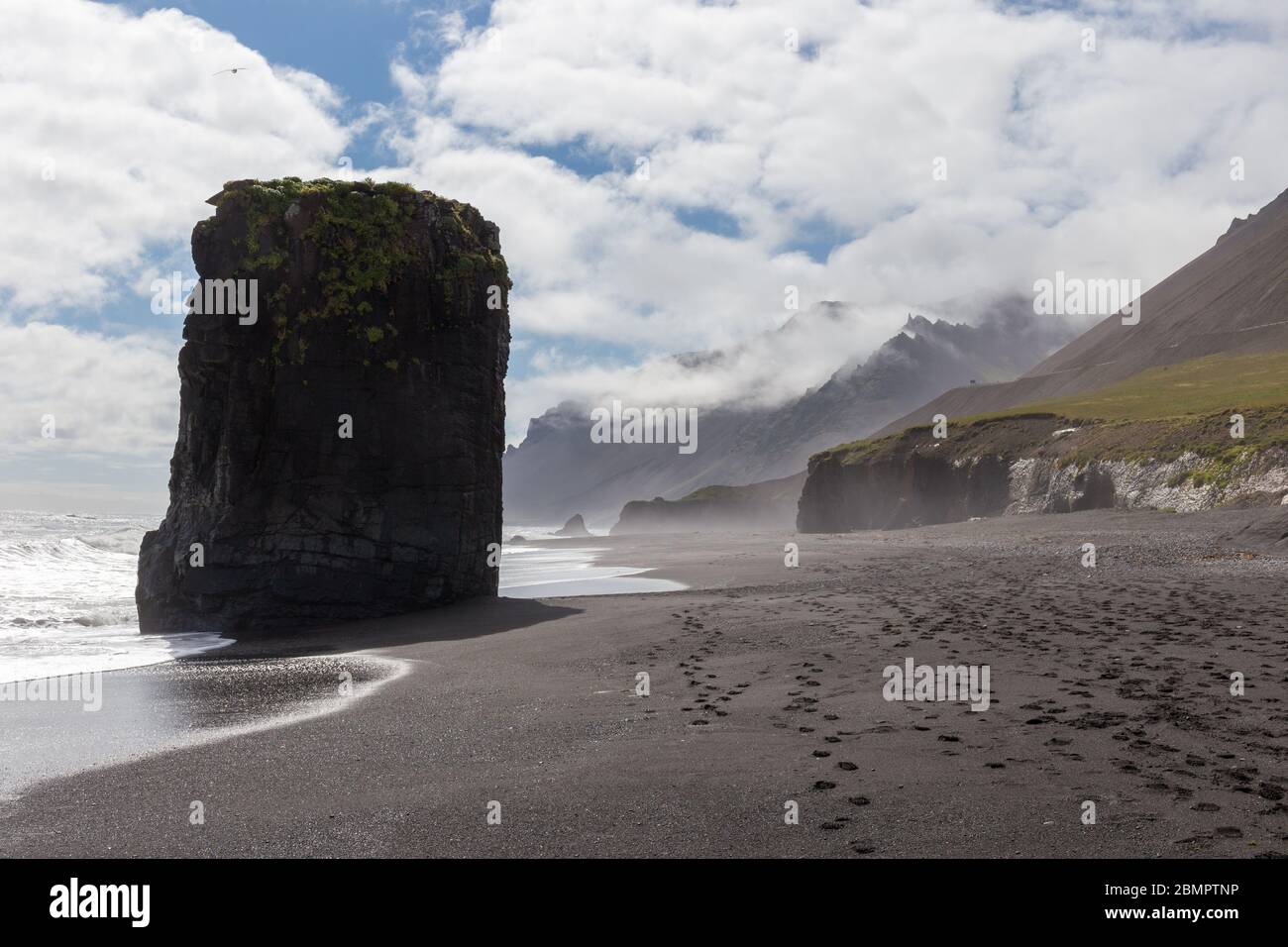 Hinterleuchtete Felsen am schwarzen isländischen Strand Stockfoto