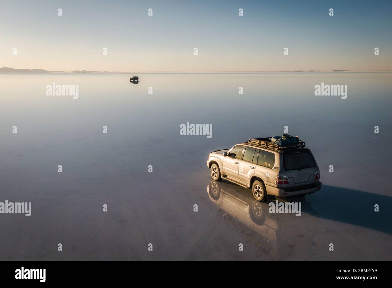 4WD Fahrzeuge erkunden Uyuni Salt Flats (Spanisch: Salar de Uyuni ) bei Sonnenaufgang in Bolivien, Südamerika. Stockfoto