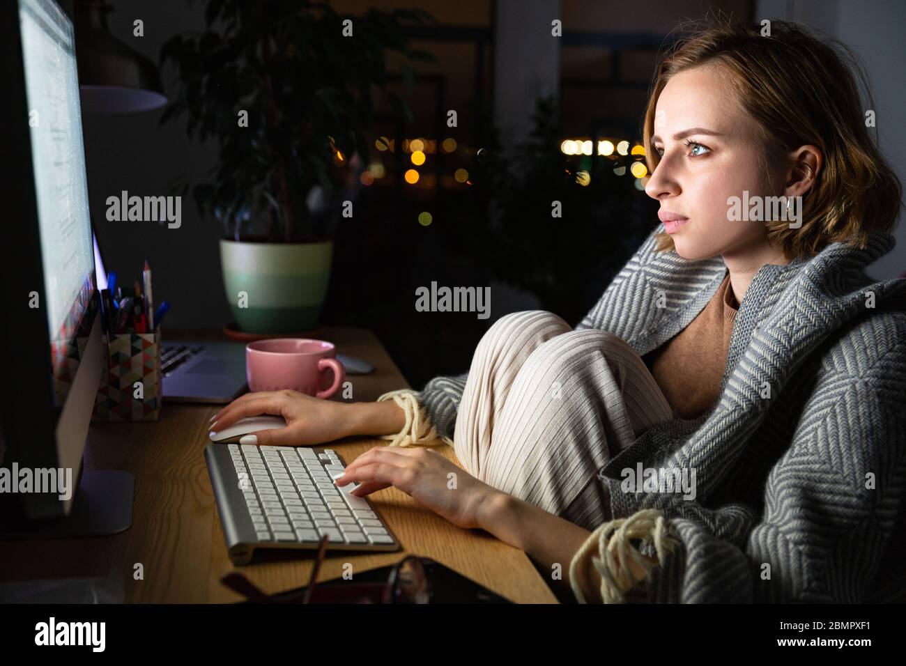 Nahaufnahme der jungen Frau, die am Desktop-pc spät in der Nacht im Home Office, kann nicht schlafen, süchtig Nachrichten über Coronavirus oder Social Media teilen. Kostenlos Stockfoto