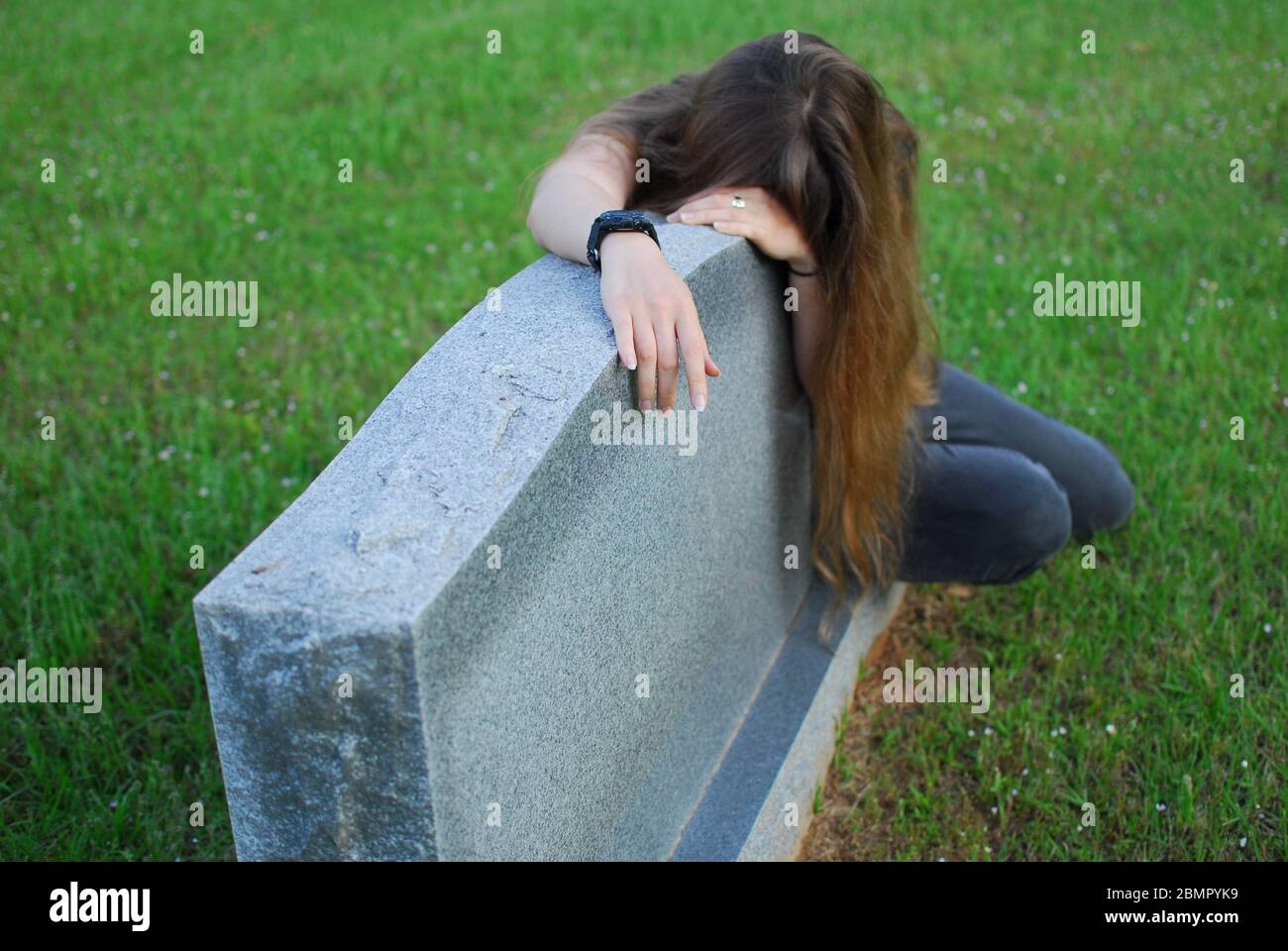 Eine Frau trauert um einen Grabstein. Stockfoto
