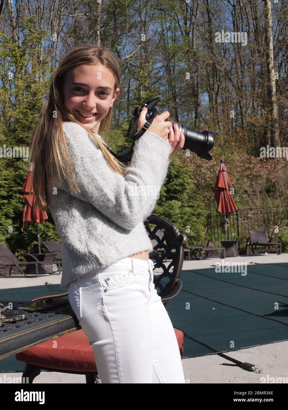 Junge Mädchen schärfen ihre neue Fähigkeit mit einer DSLR-Kamera am Muttertag 2020 in Sparta, New Jersey. Glücklich mit ihren Ergebnissen bekommt ein großes Lächeln. Stockfoto
