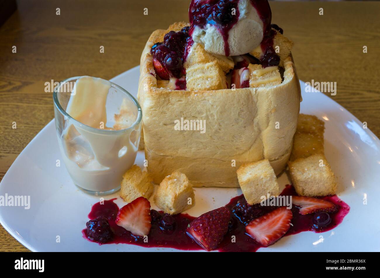 Süßes Brioche-Brot mit Beerenmarmelade und Eis. Kreatives Dessert Stockfoto