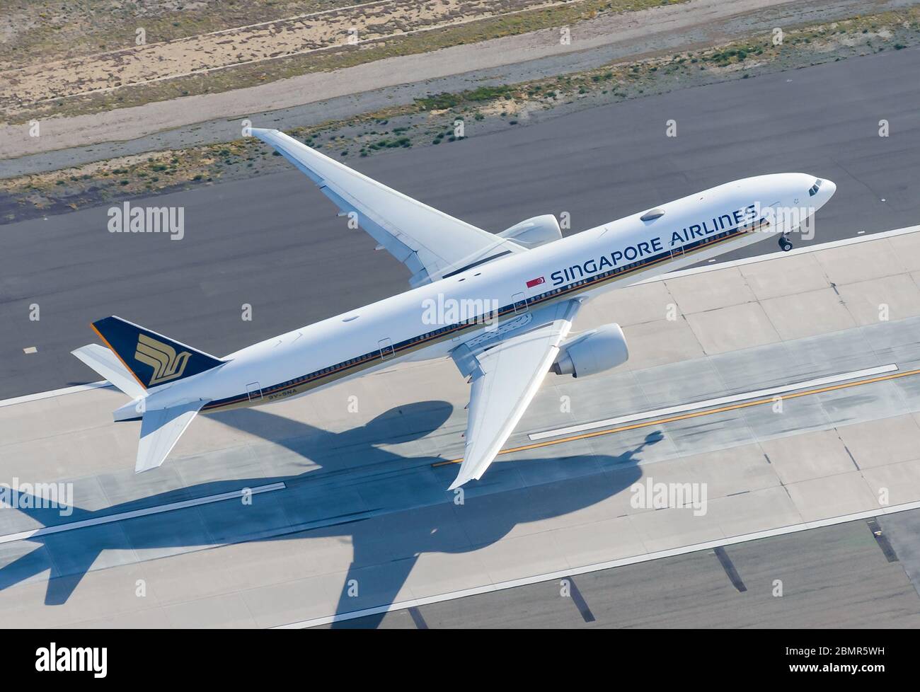 Singapore Airlines Boeing 777 startet mit der Start- und Landebahn des LAX International Airport. Luftaufnahme des B777 oder 77W-Strahls, der aus einer Luftaufnahme mit hohem Winkel abgeht. Stockfoto
