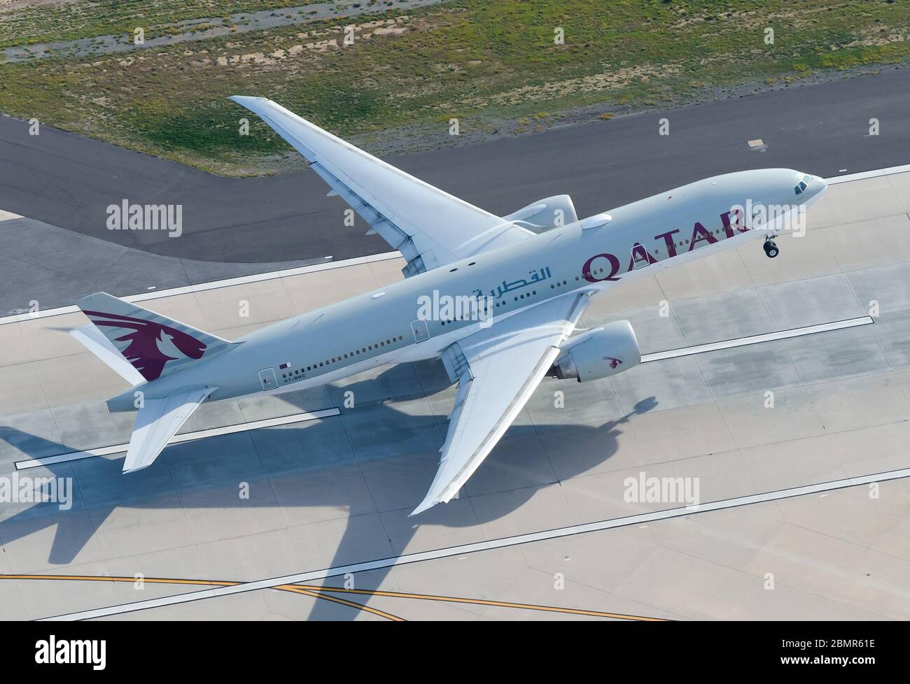 Qatar Airways Boeing 777 startet mit der Start- und Landebahn des LAX International Airport. Luftaufnahme des B777-Strahls, der aus einem hohen Winkel nach Doha, Katar, abbricht. Stockfoto