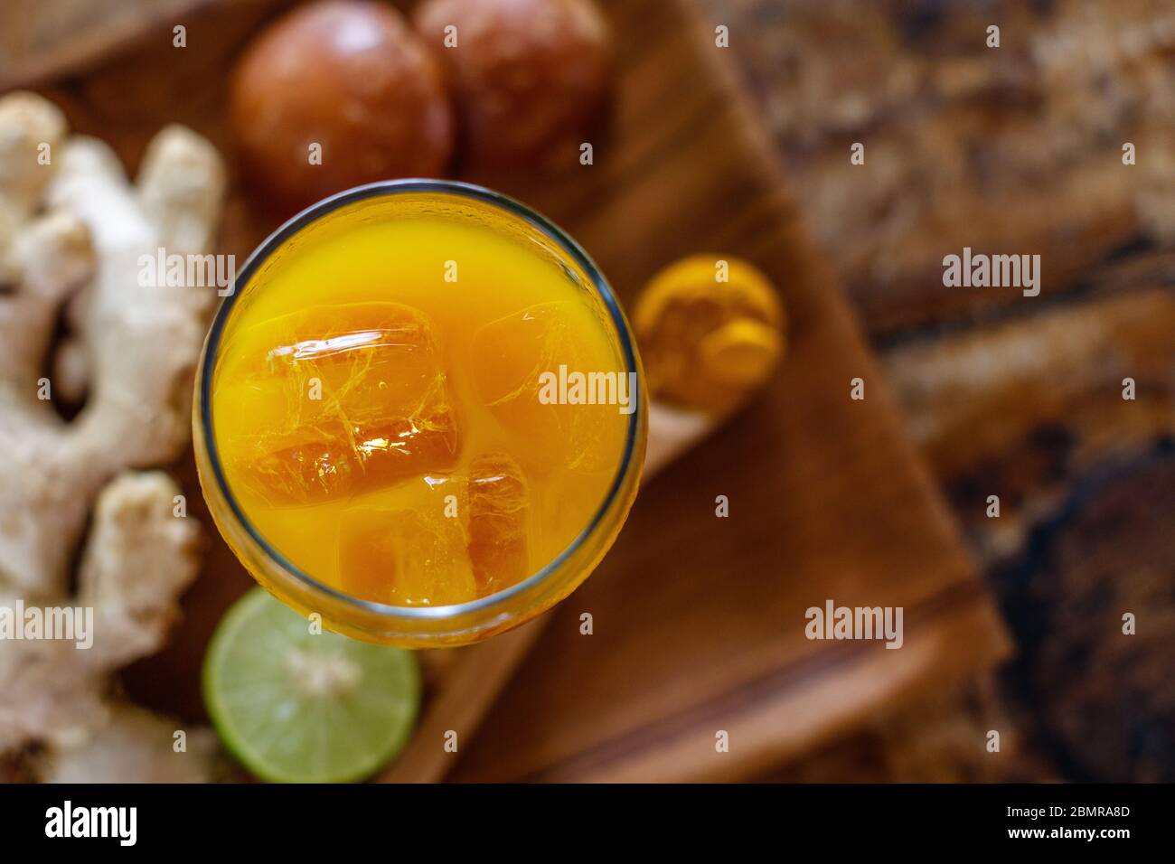 Ein Glas Jamu 'Kunir Asam', traditionelle indonesische Kräutermedizin. Serviert mit Eis. Bali, Indonesien. Draufsicht. Mit Platz. Stockfoto