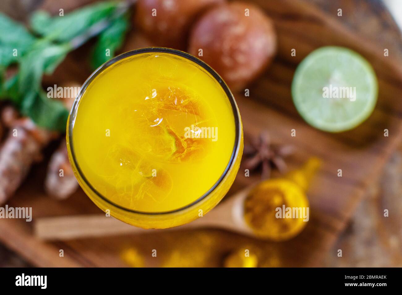 Ein Glas Jamu 'Kunir Asam', traditionelle indonesische Kräutermedizin. Serviert mit Eis. Bali, Indonesien. Draufsicht. Mit Platz. Stockfoto